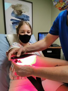 Cold Laser Therapy on a womans elbow using Bioflex LLLT system by Dr Jeda Boughton at BodaHealth in Vancouver