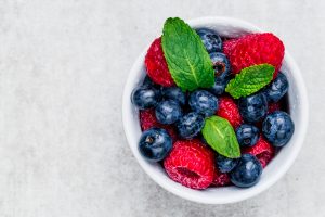 bowl of blueberries and strawberries with mint leaves