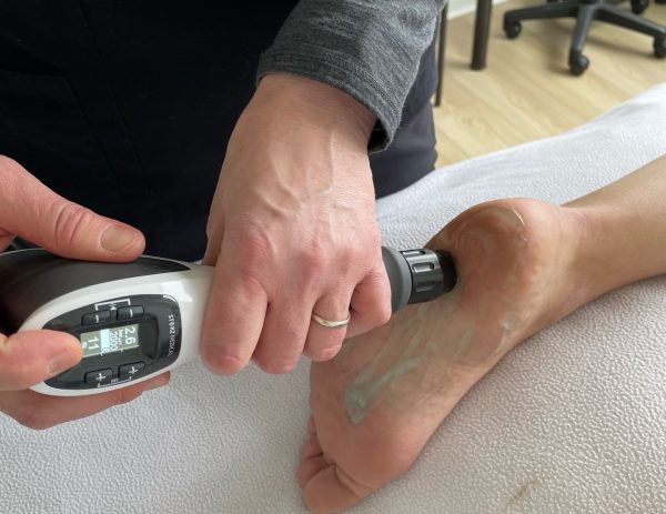 Jeda Holding Shockwave hand device in Vancouver